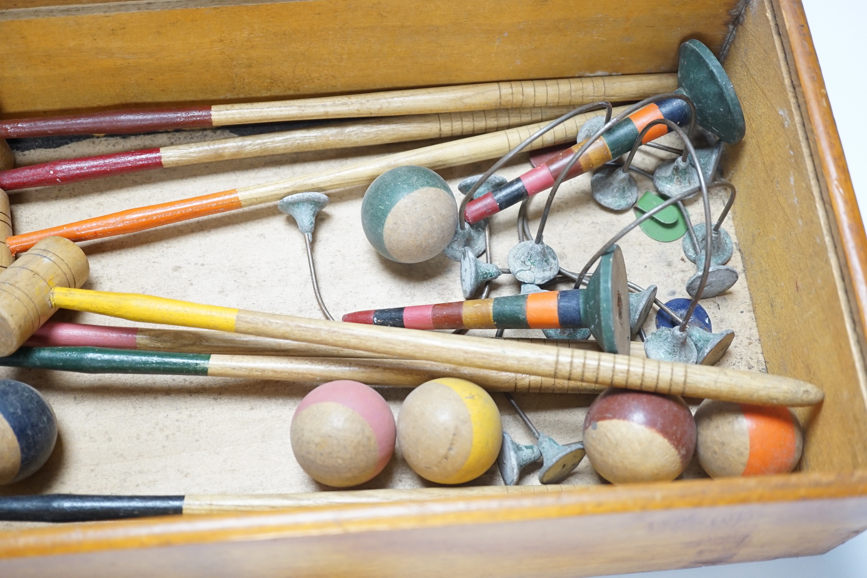 A boxed table croquet set with eight painted bats and six balls